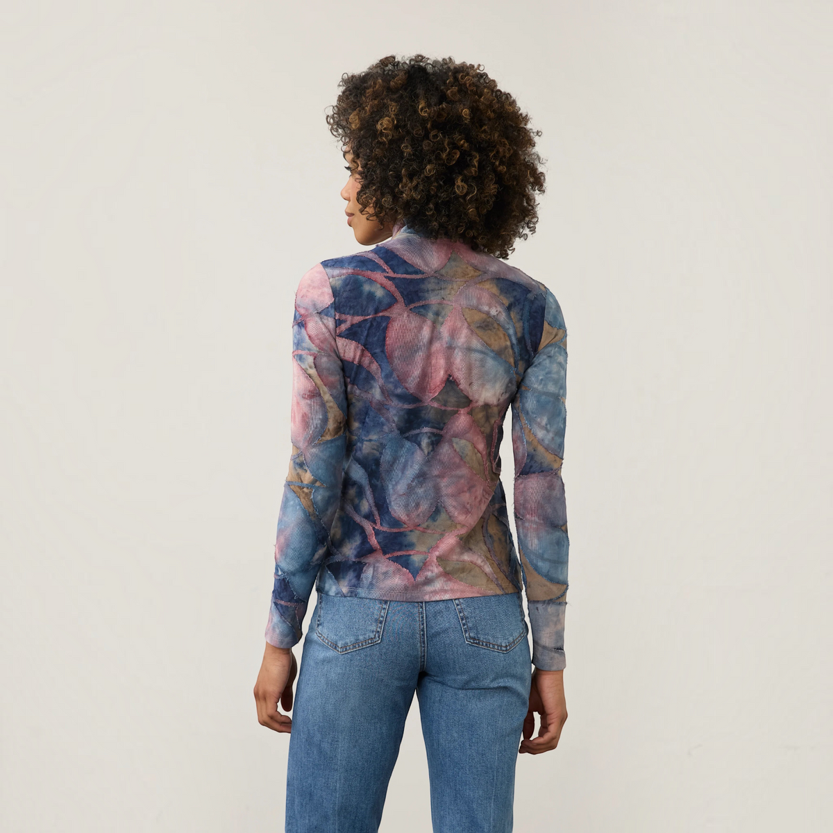 Plum Bottom FDJ long sleeve mock neck top in a blue and pink abstract leaf print worn with blue denim jeans
