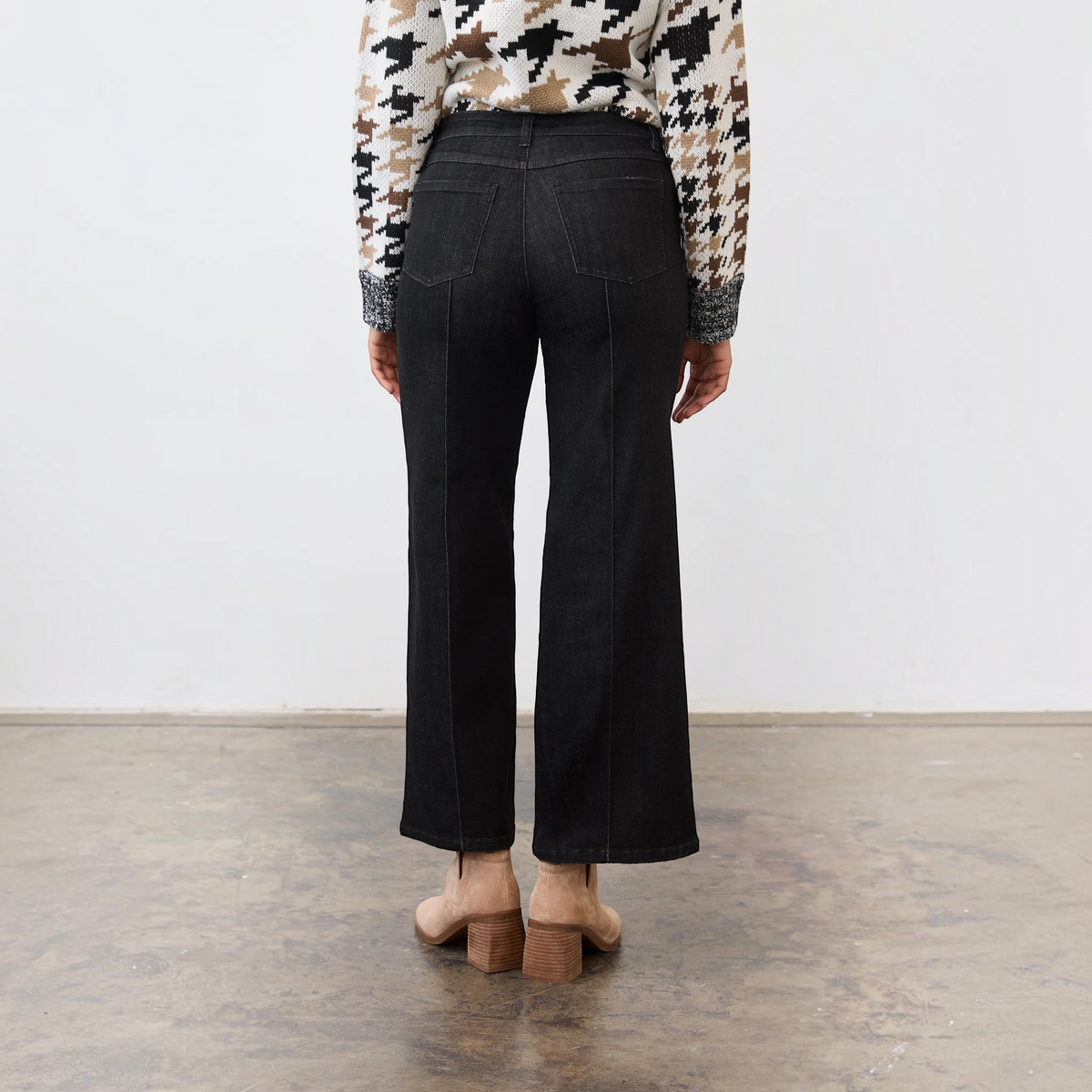 Back view of Plum Bottom FDJ Olivia black wide leg jeans with pintuck detail, worn with a houndstooth sweater.