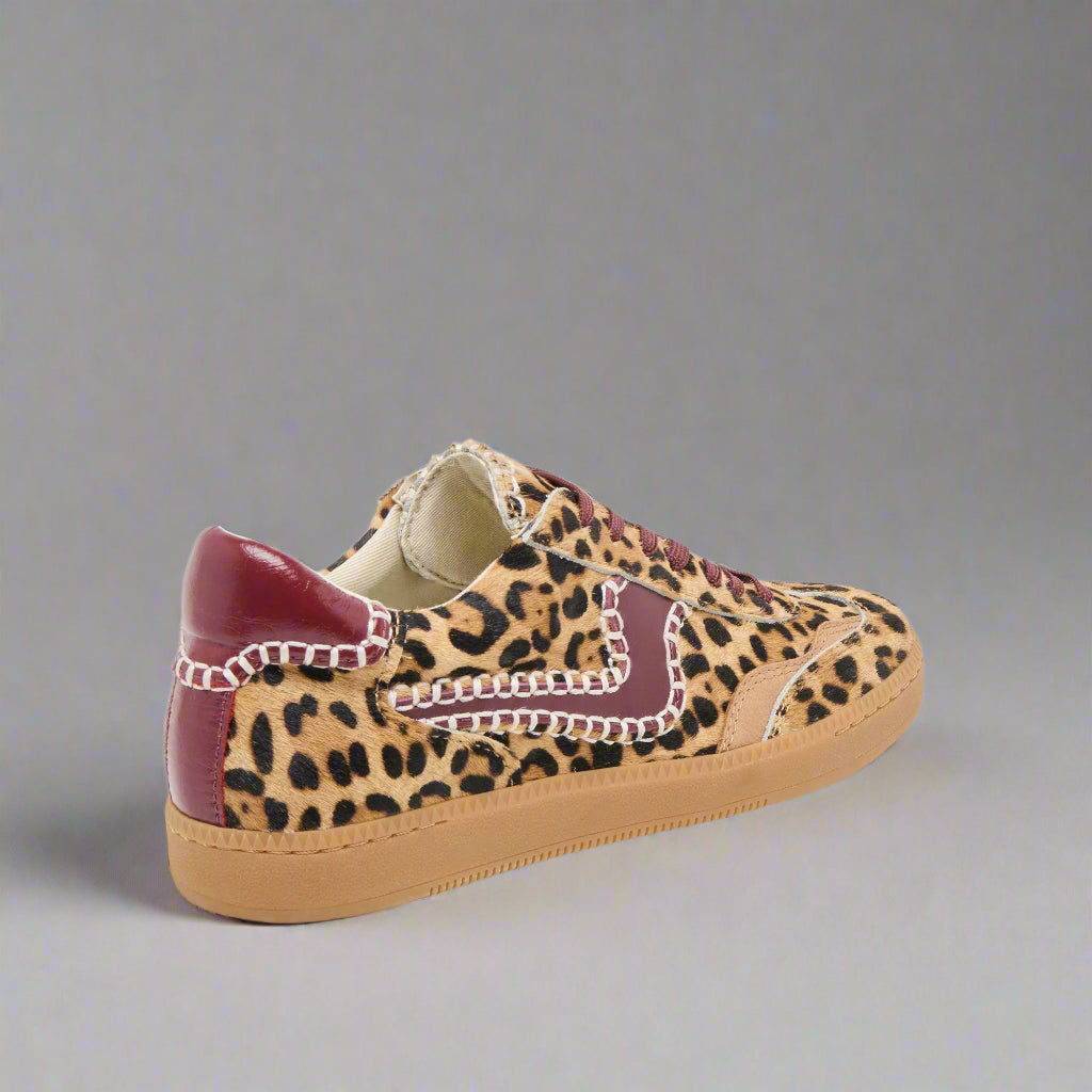 Leopard print sneaker with burgundy accents on a light gray background