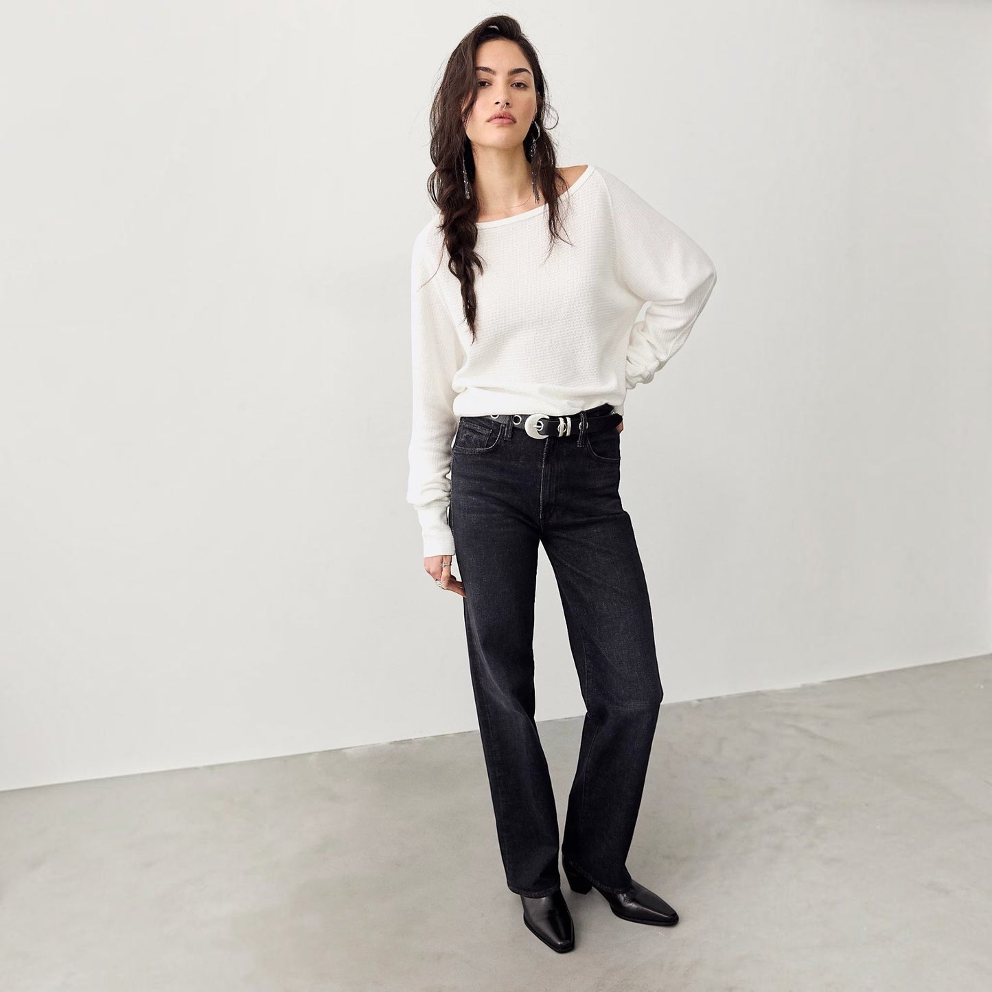 Plum Bottom model wearing a white Free People thermal long sleeve top with a boat neckline and black denim jeans.