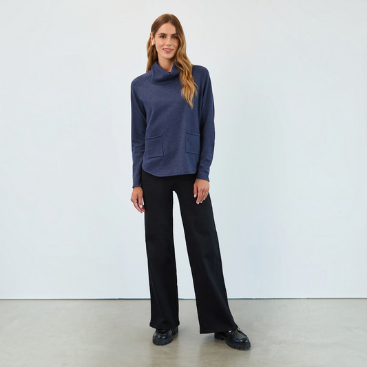 Model wearing Plum Bottom FDJ pull-on black wide leg jeans with a navy blue cowl neck top and black loafers