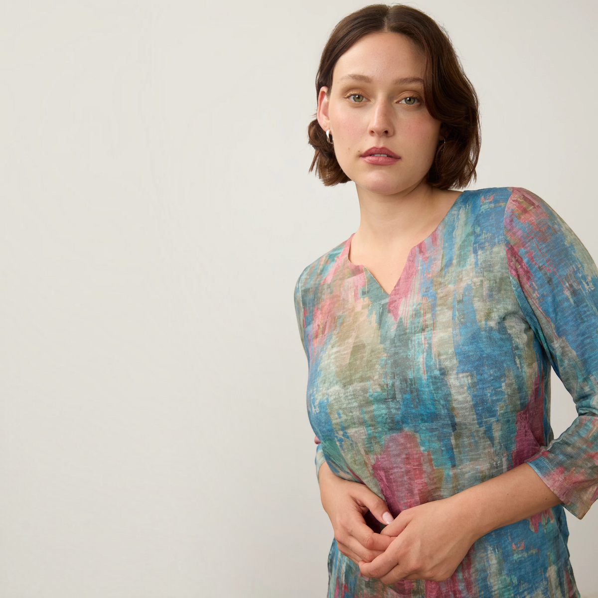 Plum Bottom FDJ notch neck top featuring a multi-colored abstract print on soft knit fabric with three-quarter sleeves