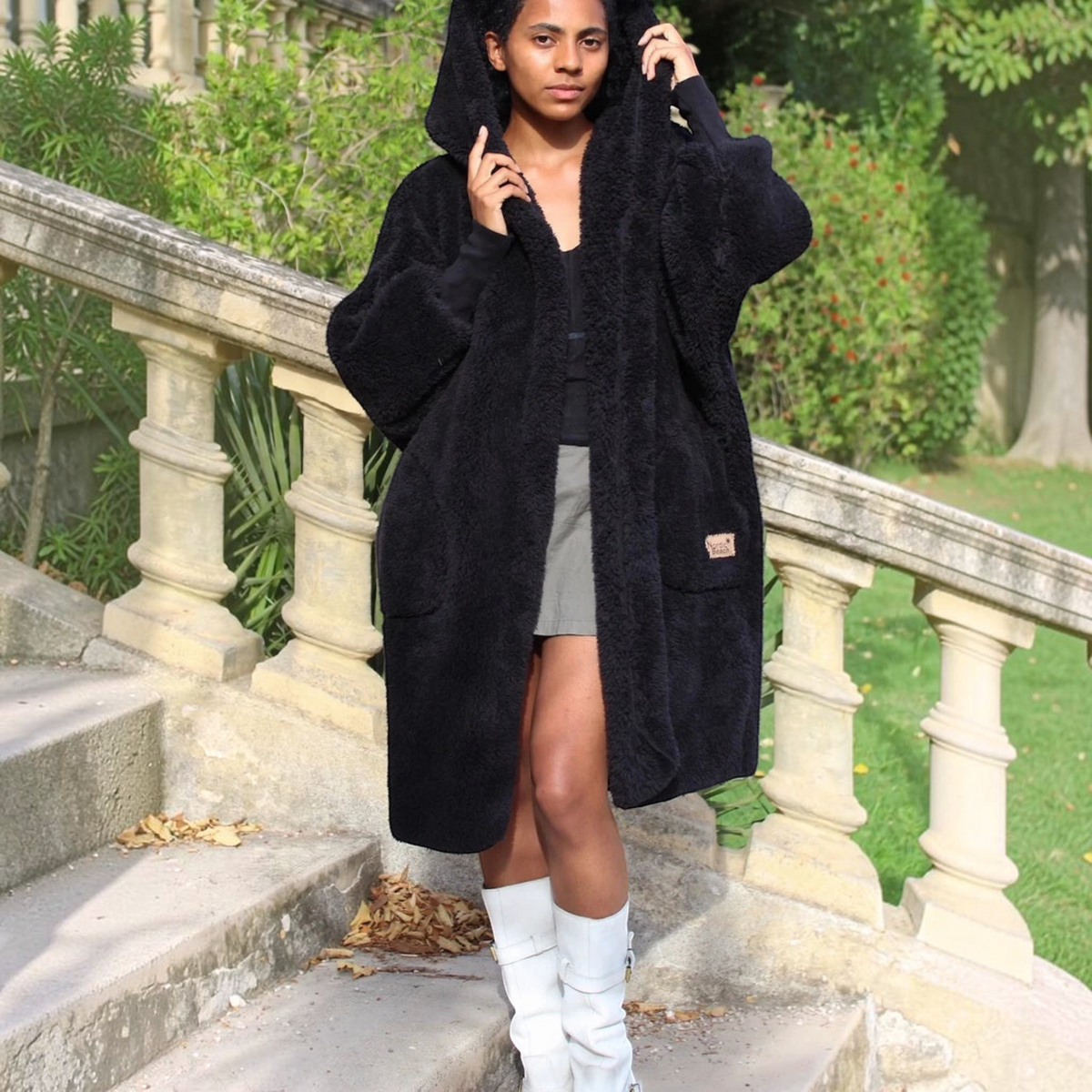 Plum Bottom NORDIC BEACH black hooded long body wrap in plush fleece material worn by a model outdoors