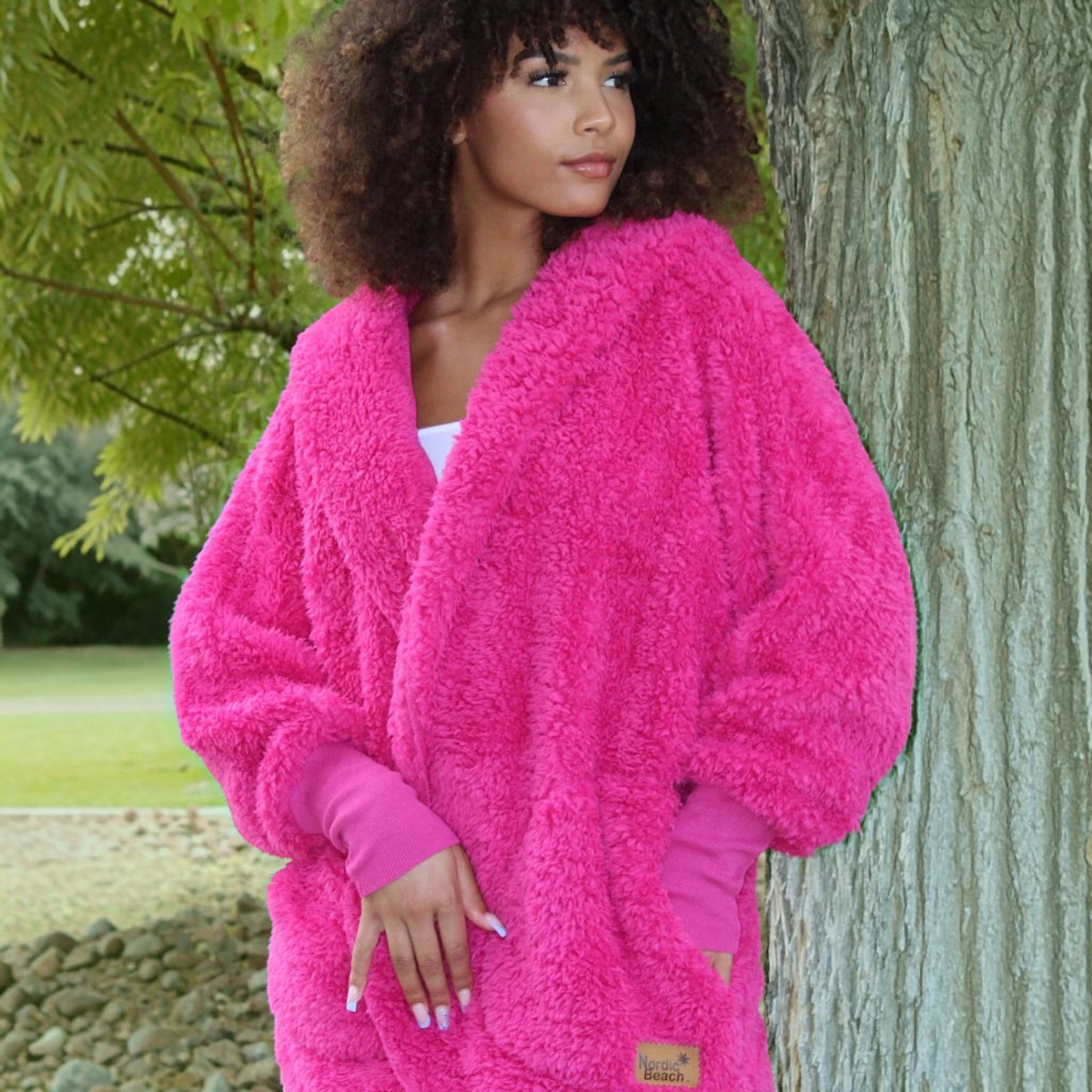 Plum Bottom NORDIC BEACH hot pink fuzzy hooded long body wrap with ribbed cuffs worn by a woman outdoors