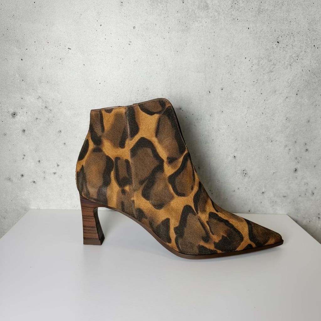 Leopard print high heel ankle boot on a studio backdrop