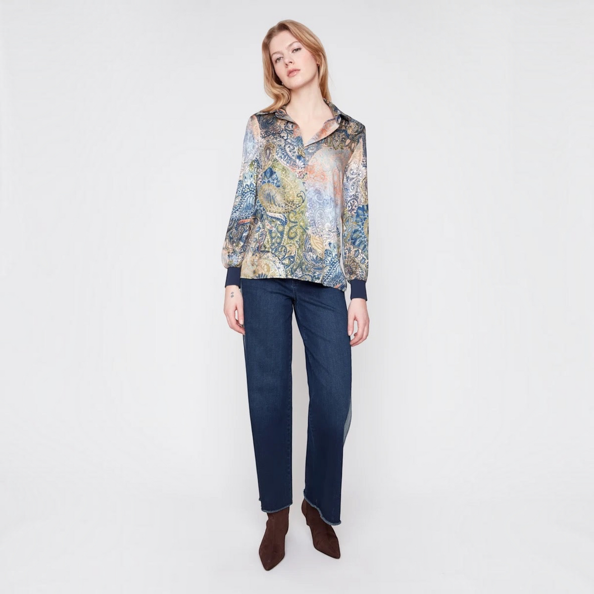 Model wearing a Plum Bottom RENUAR olive paisley print blouse with a collared neckline and navy blue cuffs.
