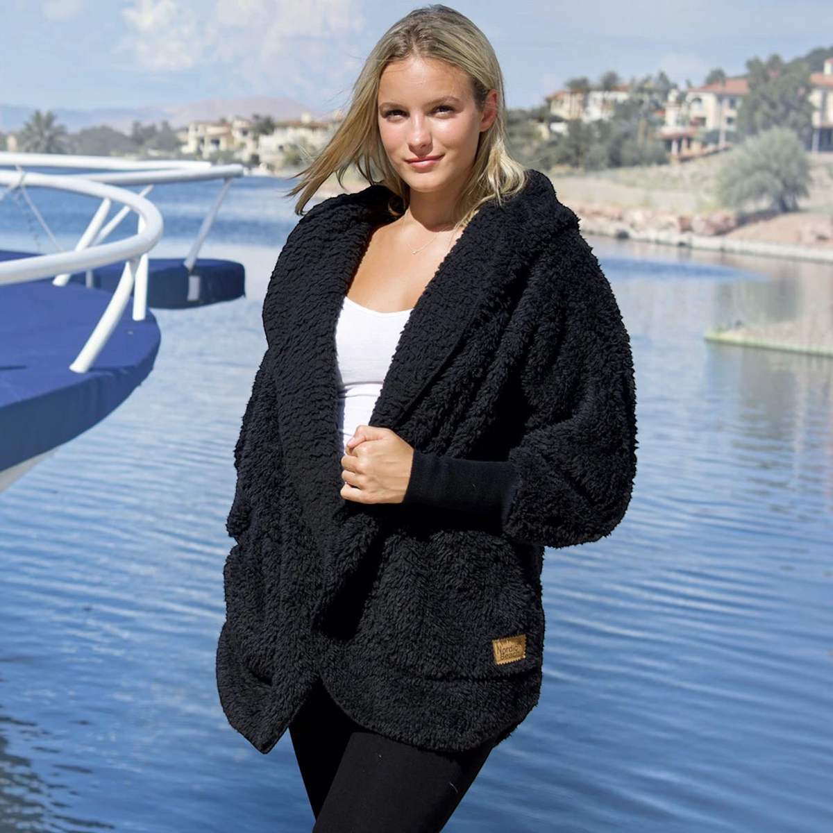 Plum Bottom NORDIC BEACH black hooded body wrap in fluffy micro poly fabric worn by a woman outdoors