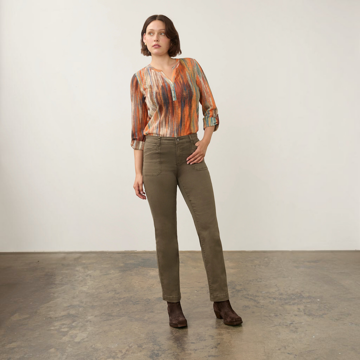 Model wearing Plum Bottom FDJ Christina olive green straight leg jeans with a patterned blouse and brown boots