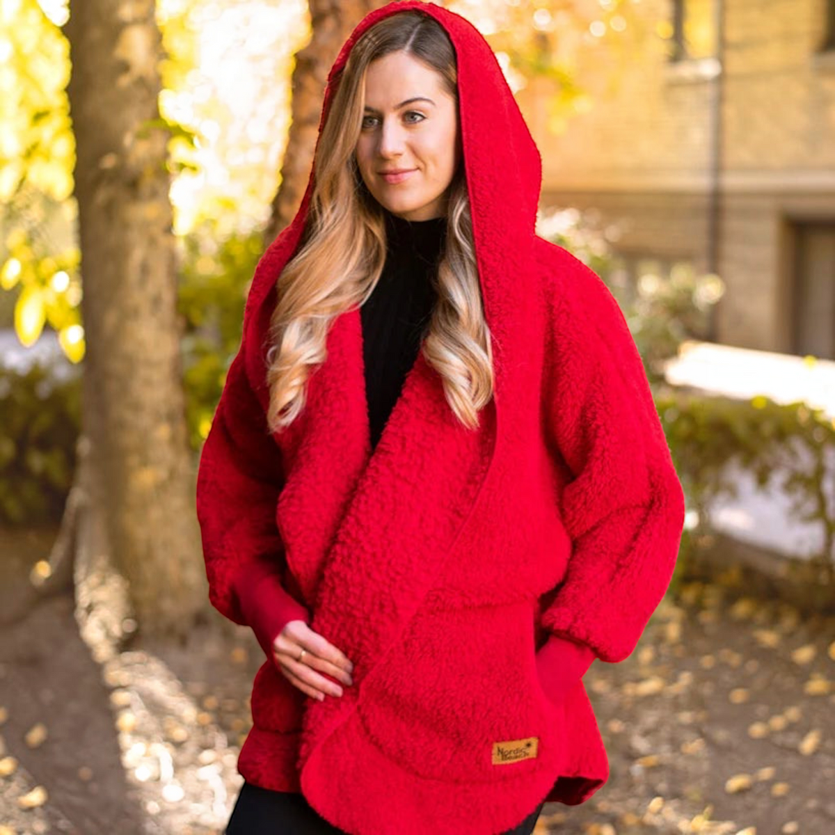Plum Bottom NORDIC BEACH red hooded body wrap in fluffy micro poly fabric worn by a woman outdoors