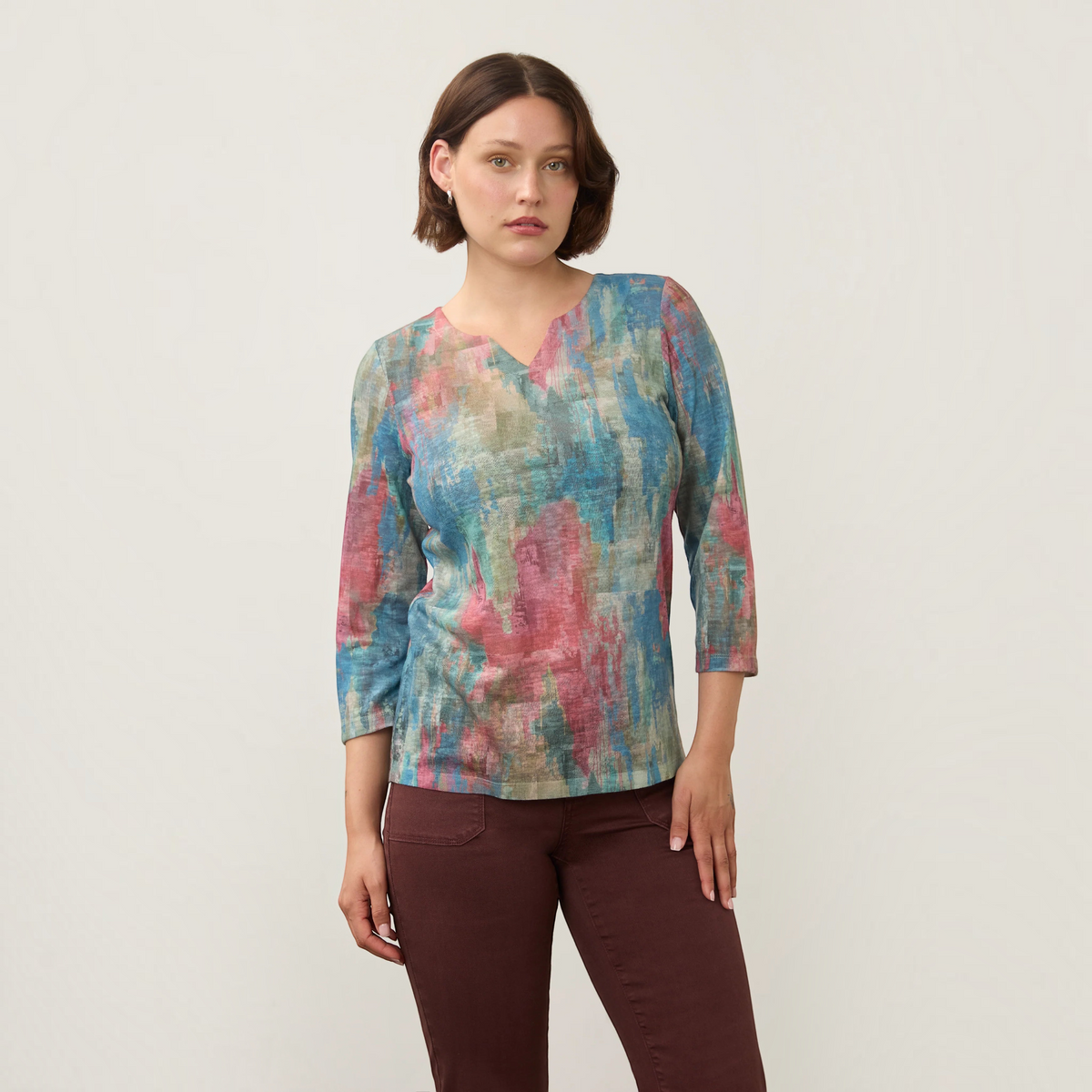 Plum Bottom FDJ notch neck top in a multi-colored abstract print with three-quarter sleeves on a female model