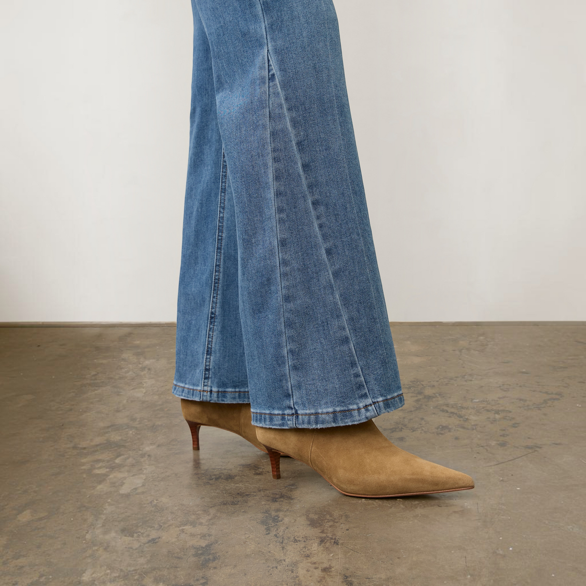 Plum Bottom FDJ Olivia bootleg jeans in medium wash denim paired with tan suede pointed-toe kitten heel boots