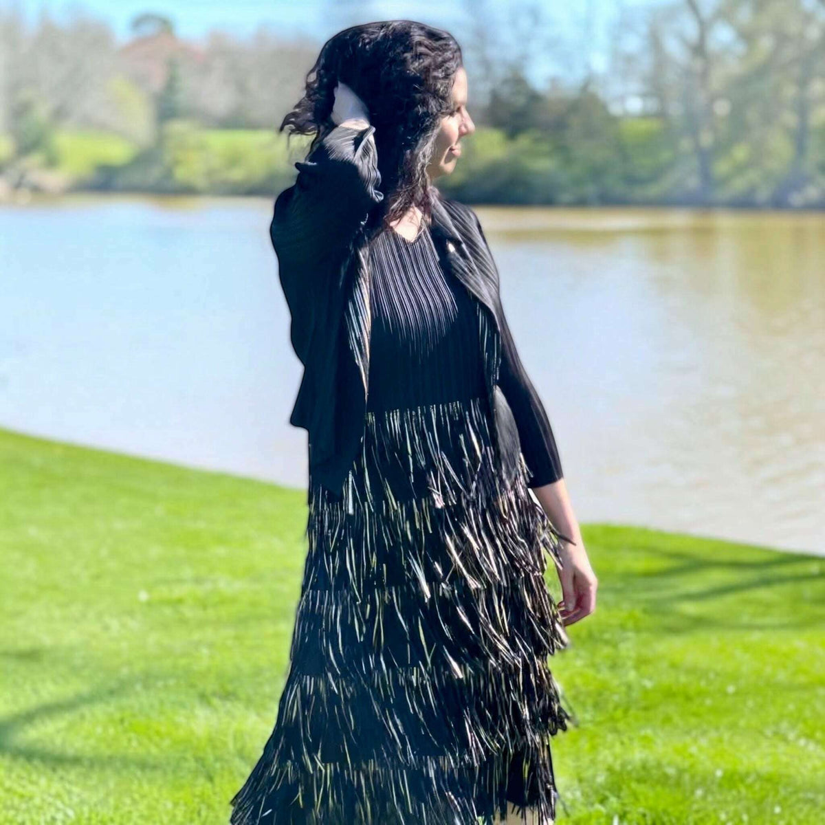 Plum Bottom Ellyndale black and gold pleated sleeveless dress and jacket set with fringe trim worn outdoors