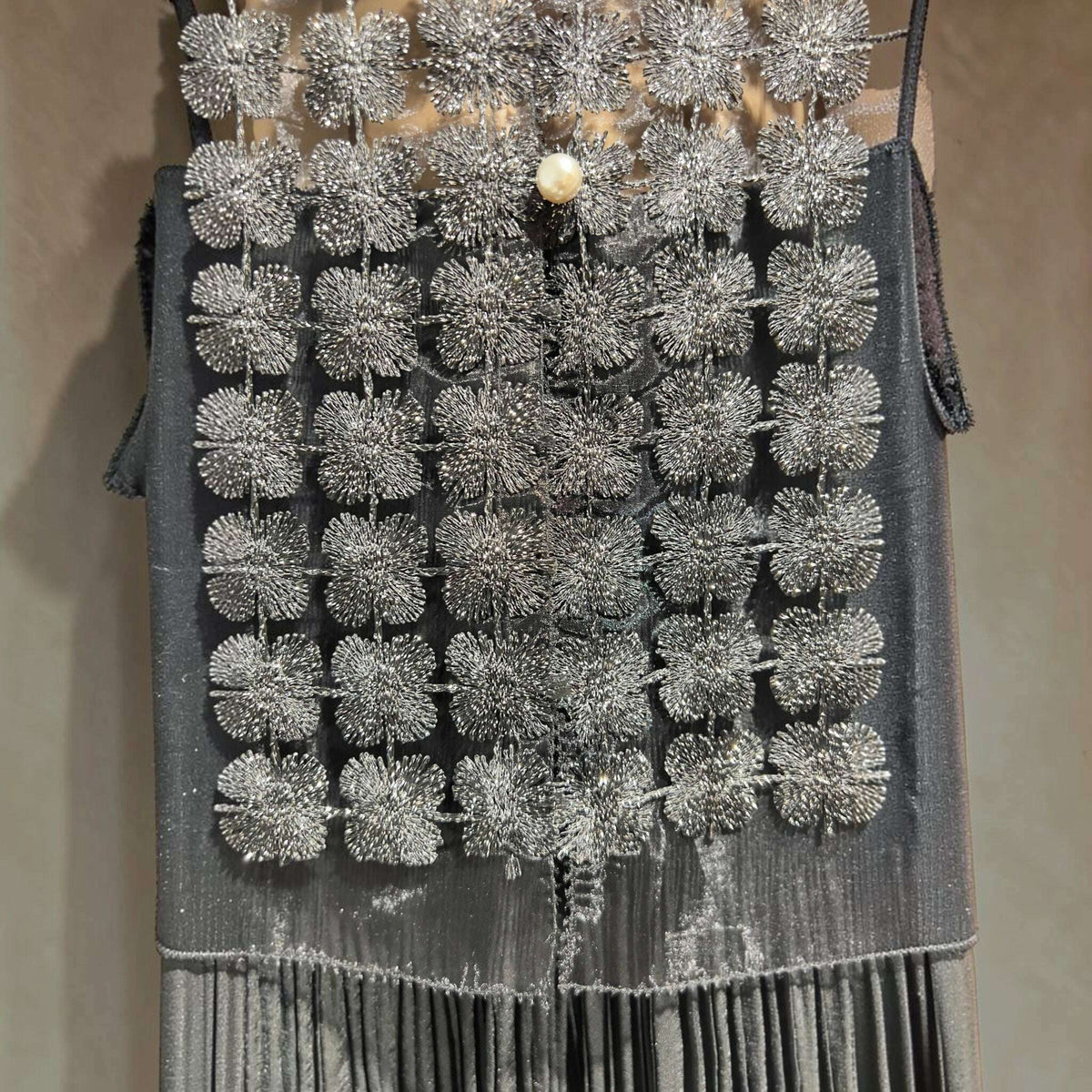 Plum Bottom ELLYNDALE black sleeveless organza vest featuring intricate metallic lace floral patterns and pearl buttons