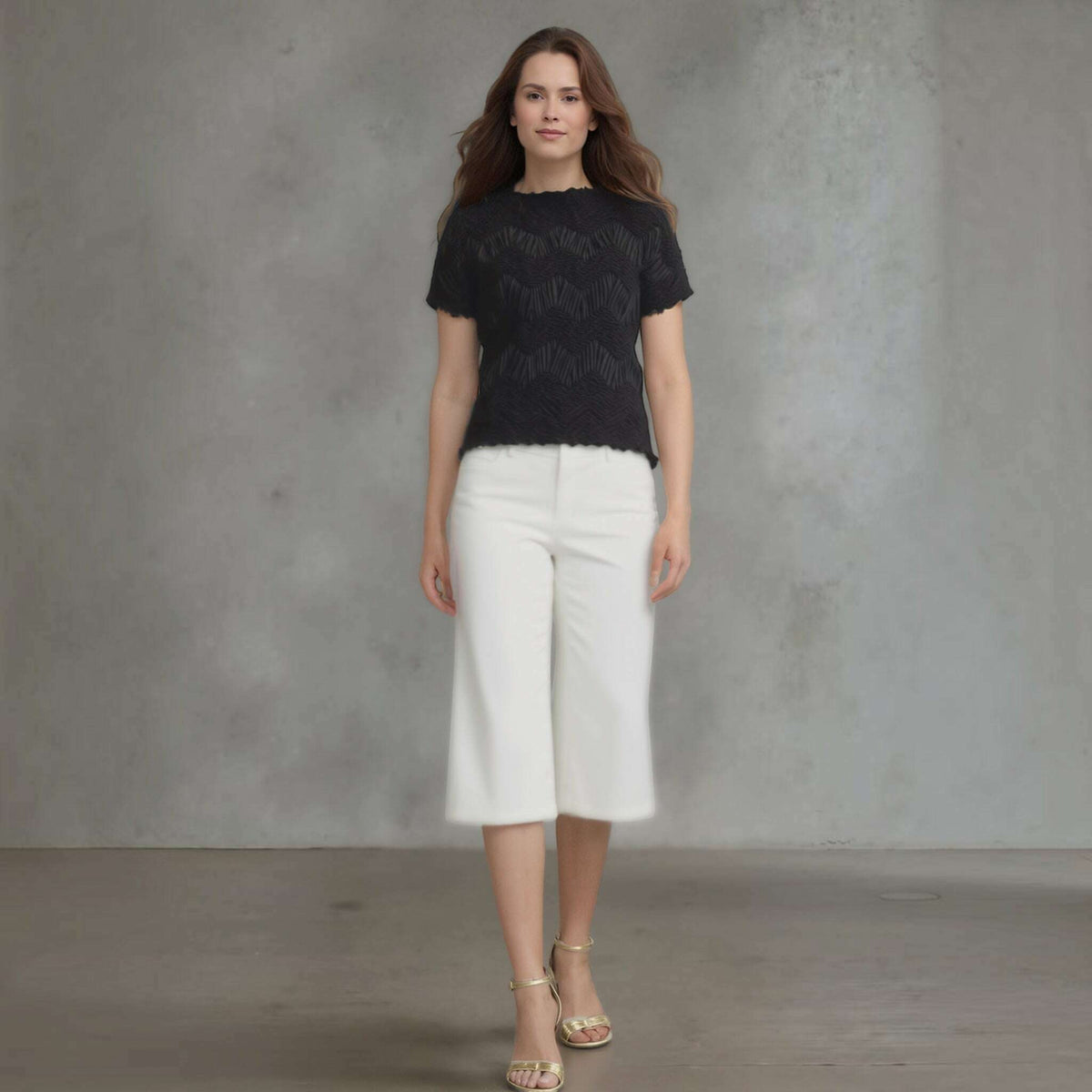 Plum Bottom Ellyndale black short-sleeve top with crochet wave pleating, worn by a model with white culottes.