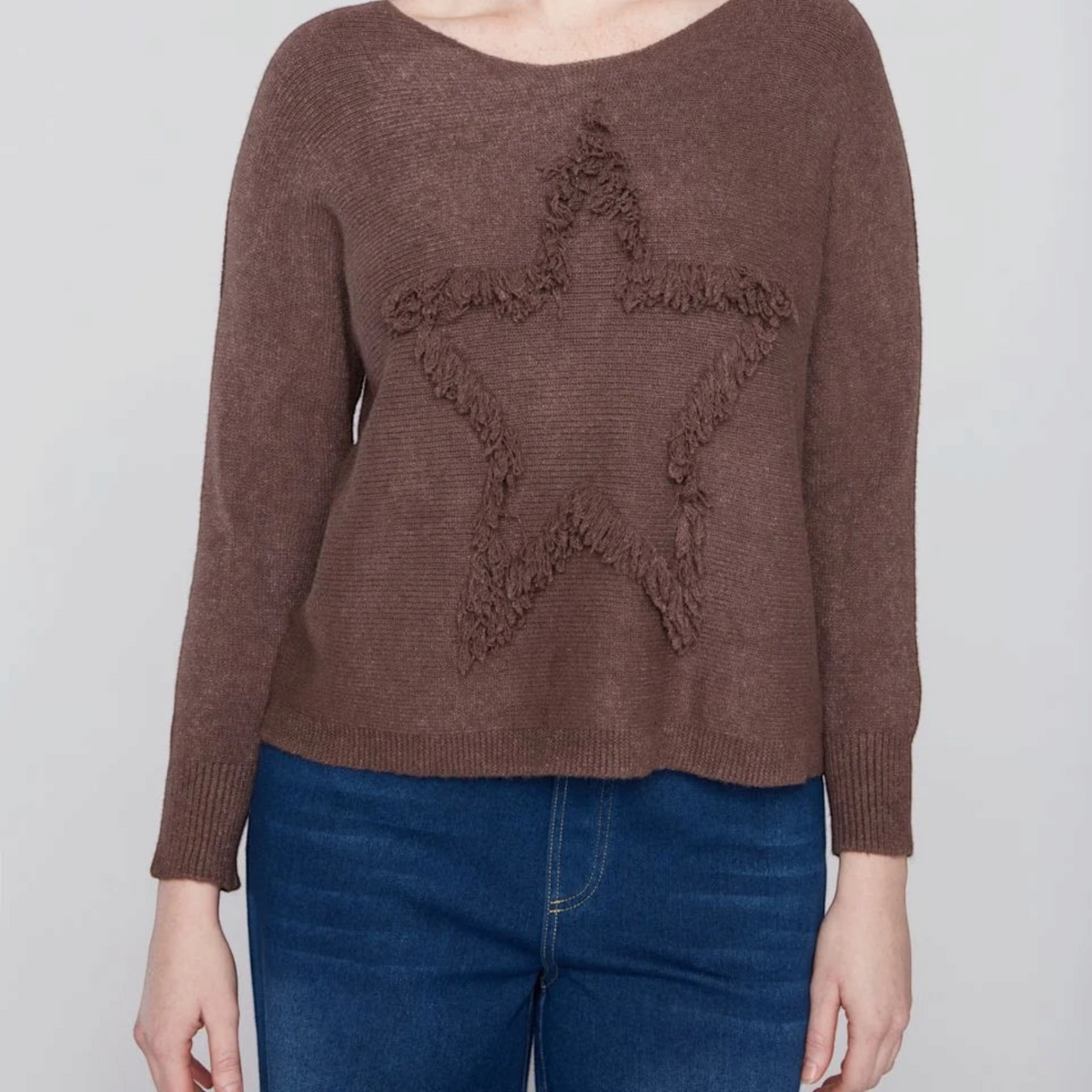 Plum Bottom COMPLI K brown knit sweater featuring a textured fringe star design on the front worn by a model
