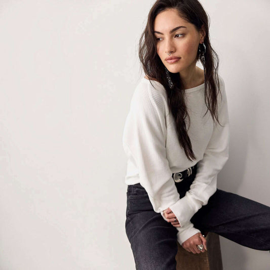 Plum Bottom model wearing a white Free People Jess long sleeve thermal top with a boat neckline and dolman sleeves.