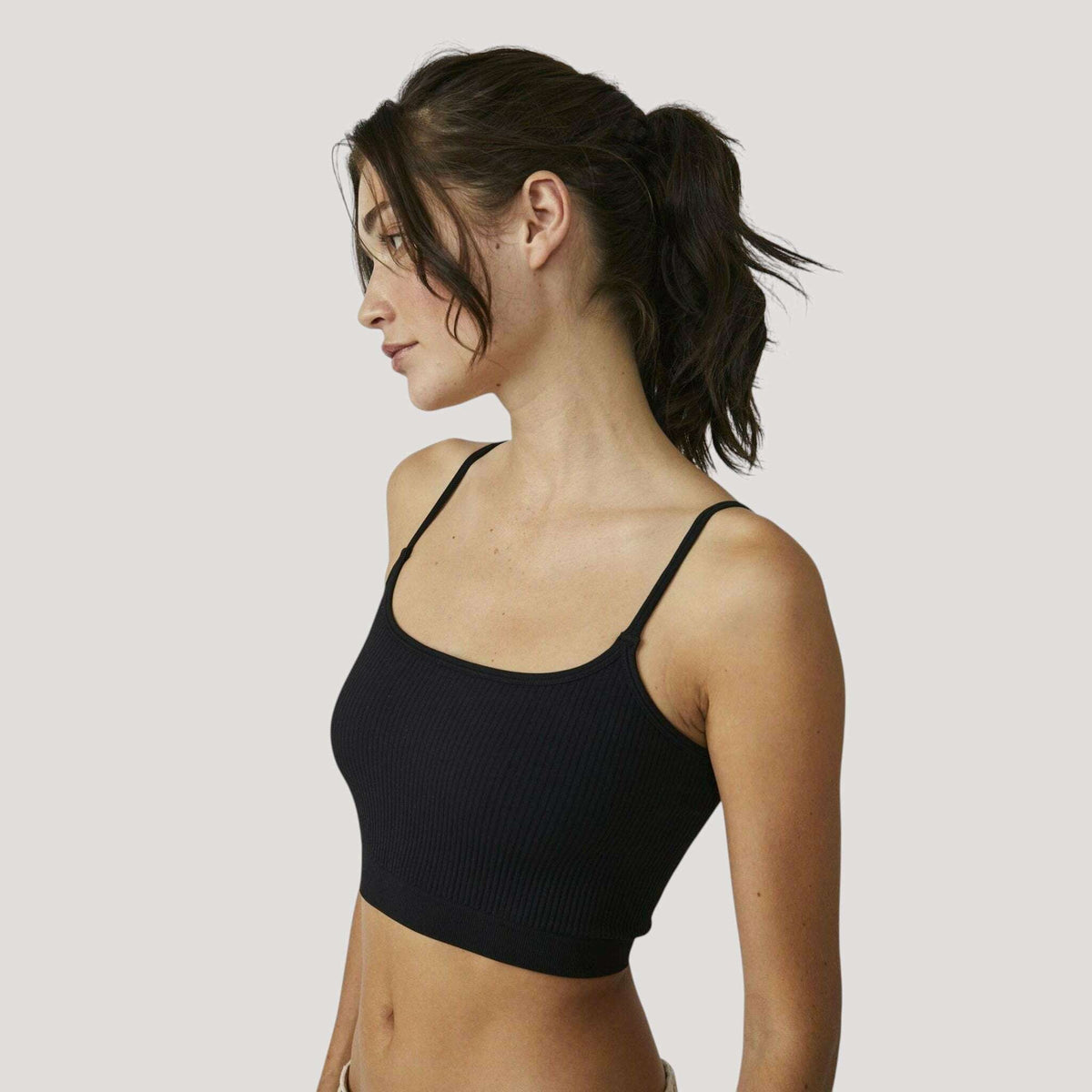 Plum Bottom Free People recycled ribbed brami in black worn by a model in a side profile view