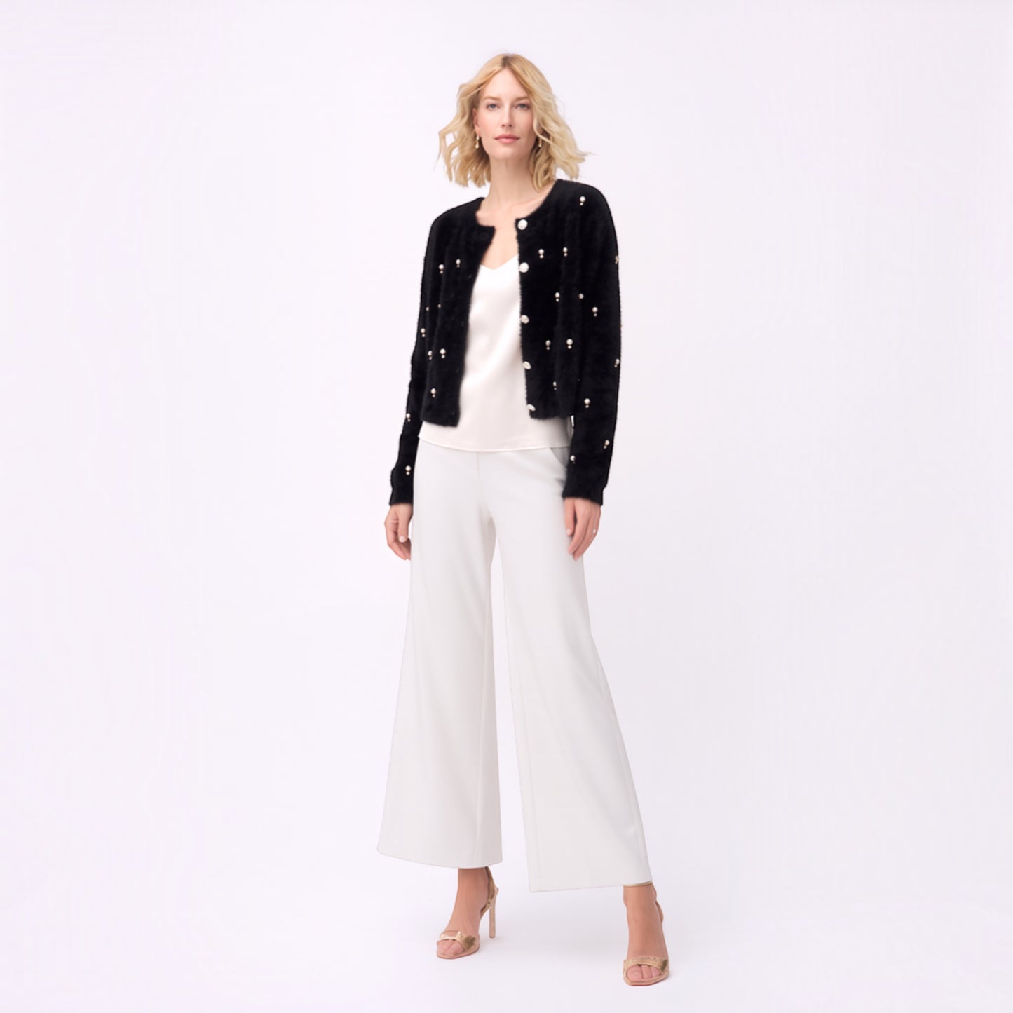 Plum Bottom black fluffy bolero with diamond and pearl embellishments worn over a white top and wide-leg trousers