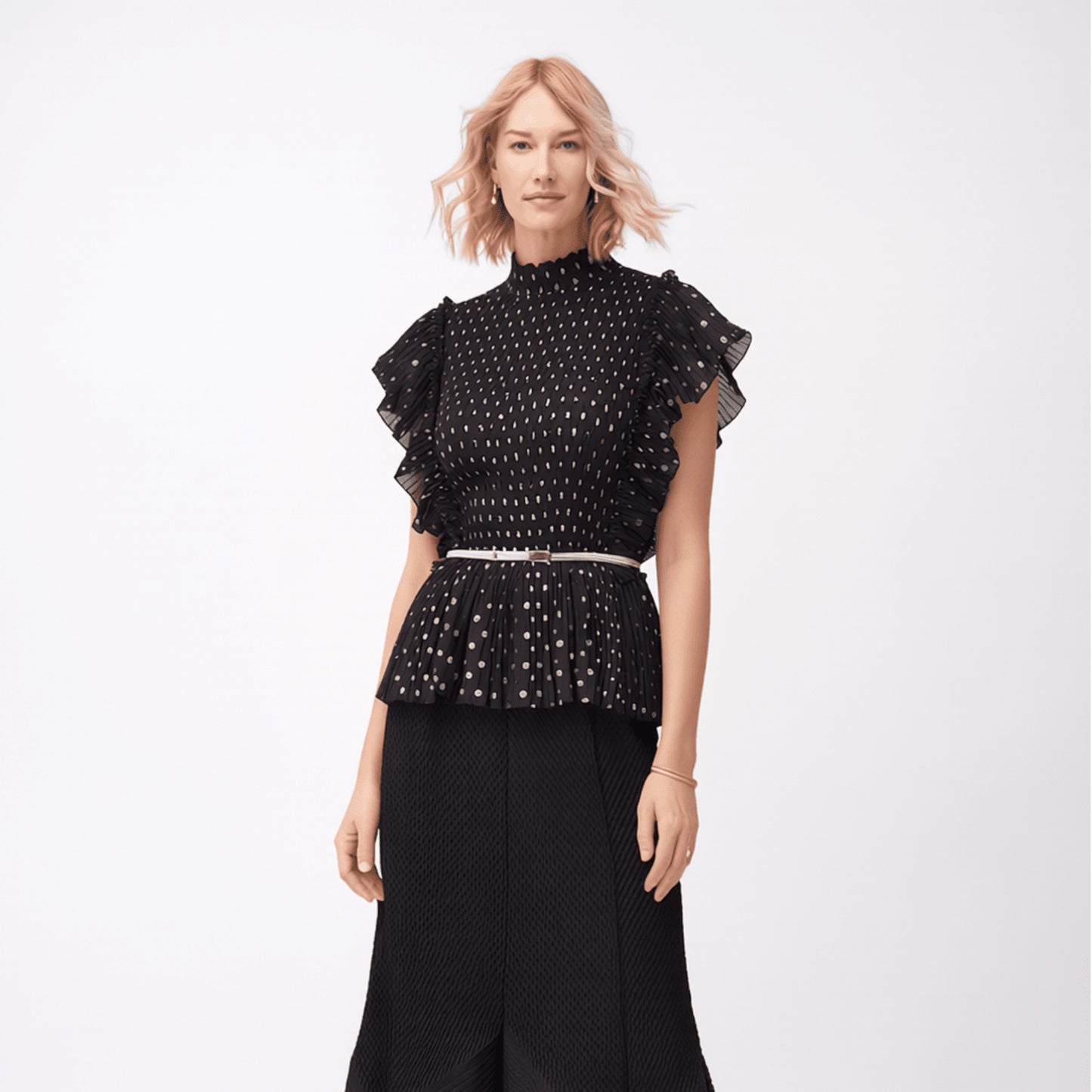 Plum Bottom black polka dot top with pleated ruffle sleeves and a high neckline worn with a matching black midi skirt.