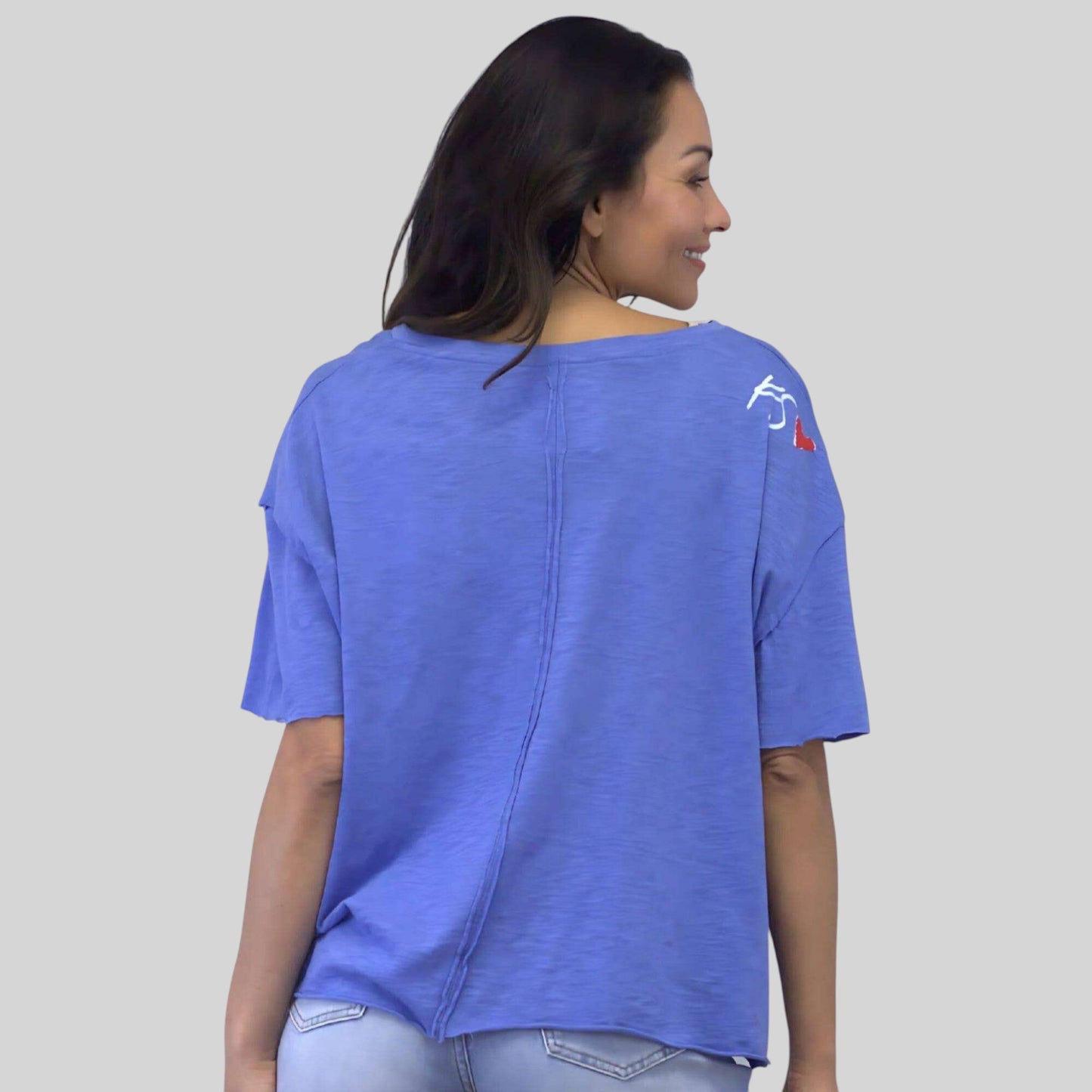 Plum Bottom Caite & Kyla Melina Tee in capri blue with back seam detail and shoulder print, worn by a woman