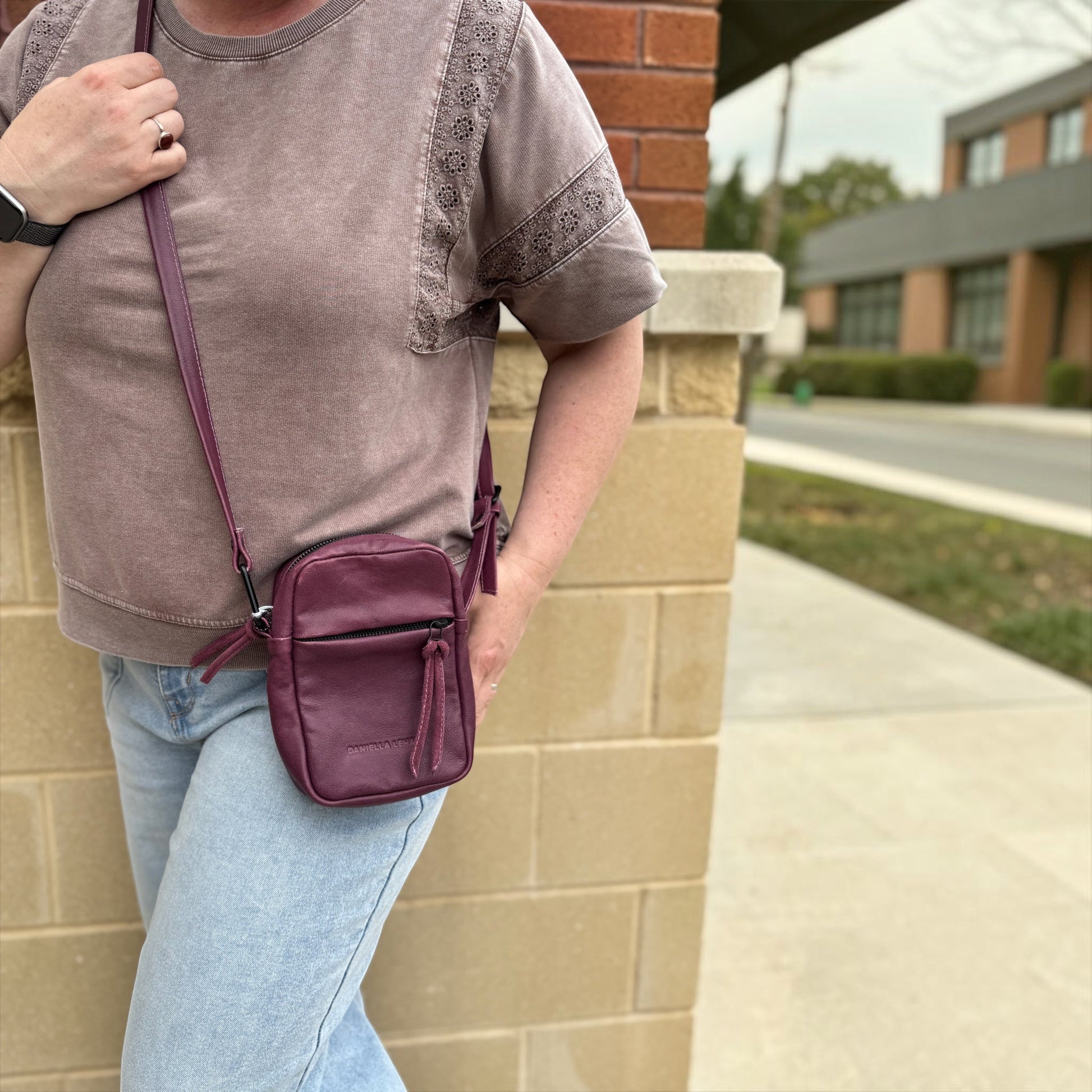 Plum Bottom DANIELLA LEHAVI Sienne mini bag in aubergine leather worn as a crossbody with a casual outfit