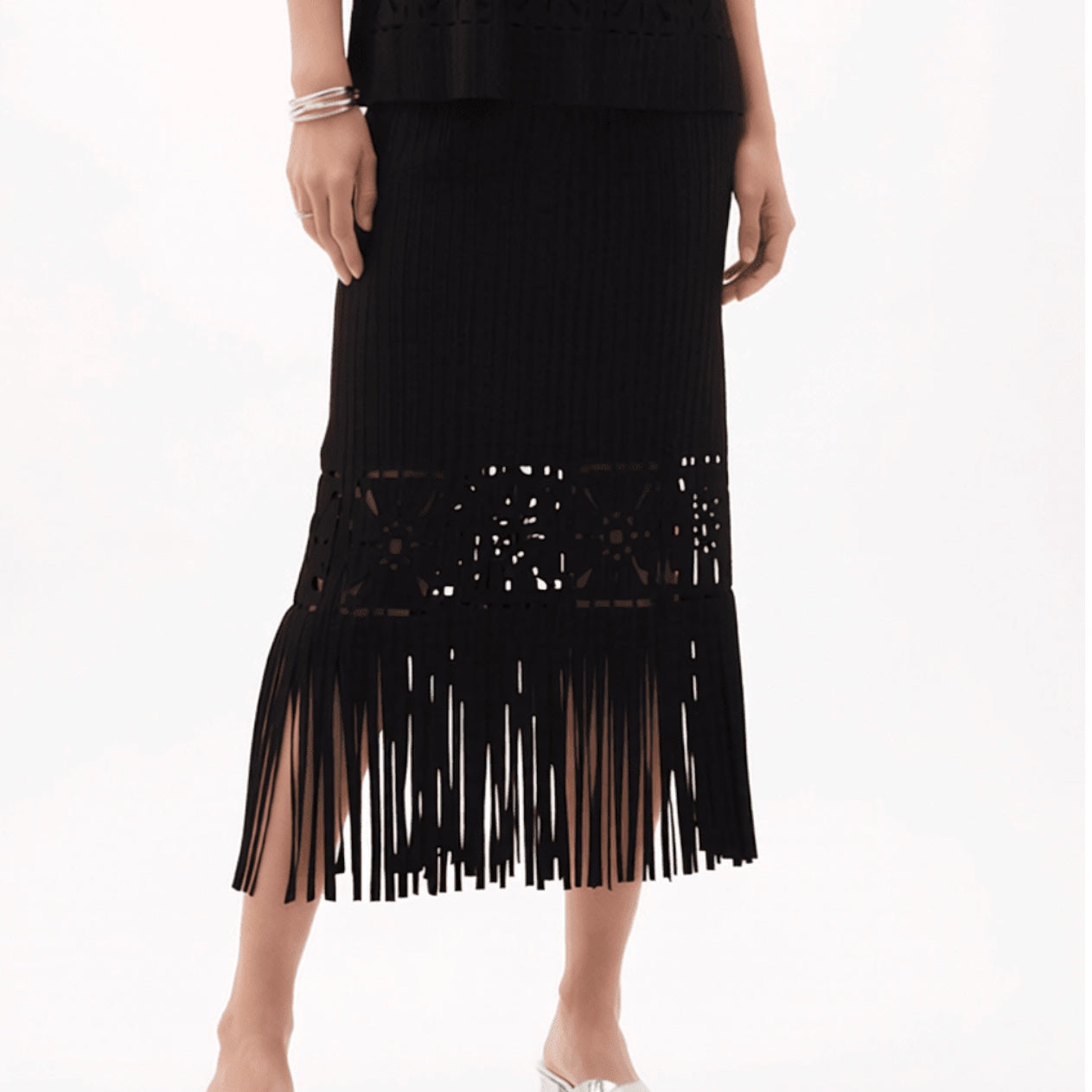 Plum Bottom ELLYNDALE black pleated midi skirt with intricate cutout details and a long fringe hem on a model