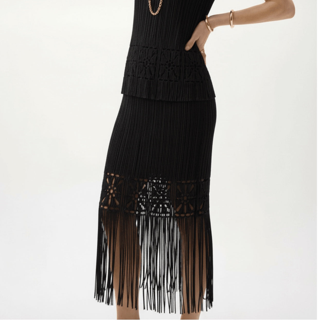 Plum Bottom ELLYNDALE black pleated midi skirt with cutout details and a long fringe hem worn by a model