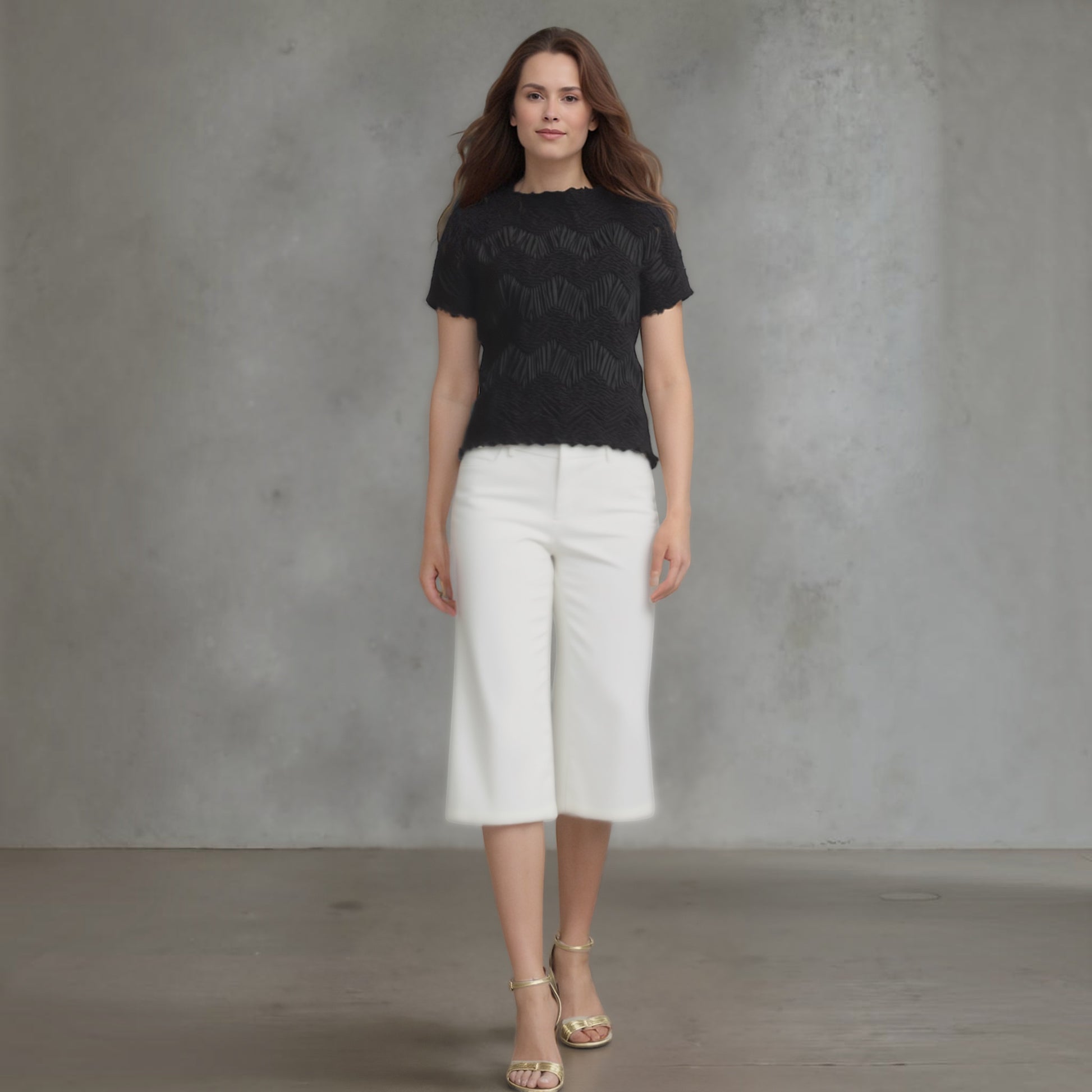 Plum Bottom Ellyndale black short-sleeve top with crochet wave pleating, worn by a model with white culottes.