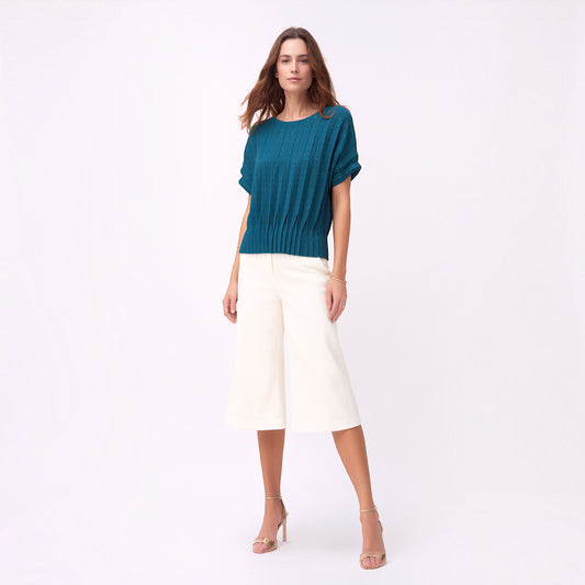 Model wearing a Plum Bottom ELLYNDALE blue pleated short-sleeve top with a dual fold design and white culottes.