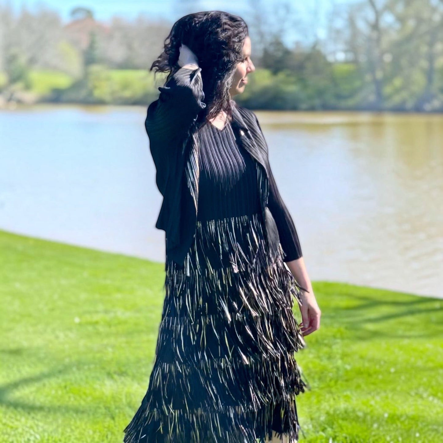 Plum Bottom Ellyndale black and gold pleated sleeveless dress and jacket set with fringe trim worn outdoors