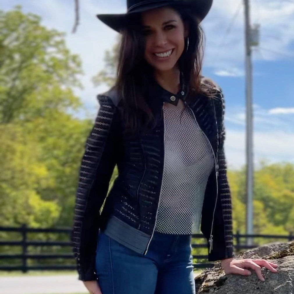 Plum Bottom ELLYNDALE Shadow Jacket featuring black faux leather, mesh panels, and a structured design on a smiling model