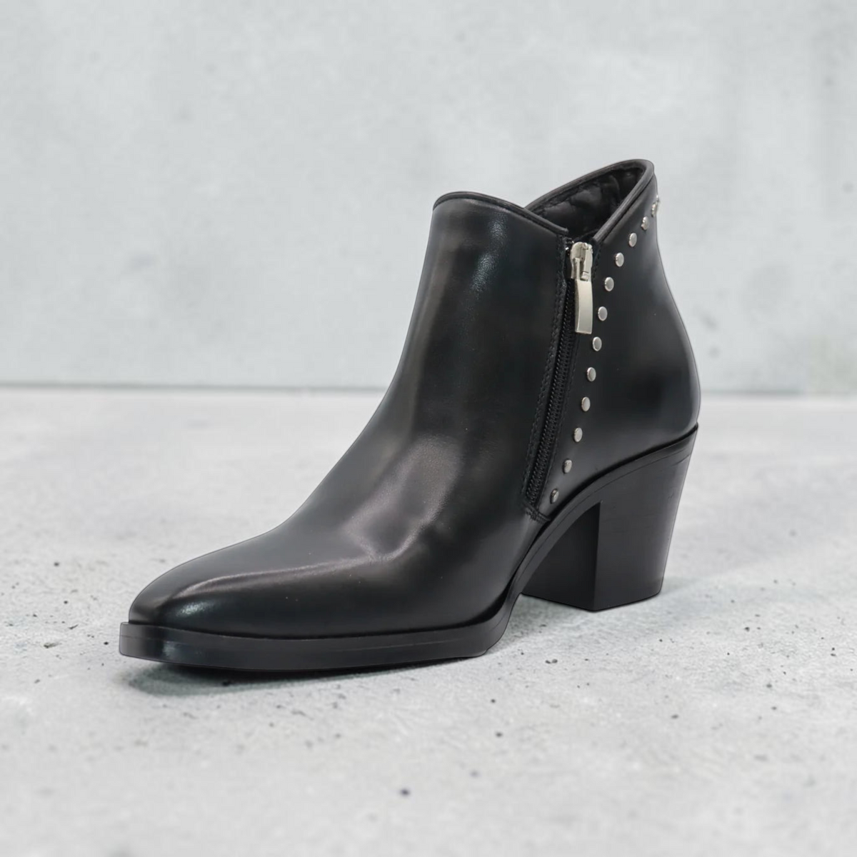 Plum Bottom Eric Michael Muriel black leather ankle boot with side zipper and silver stud accents on a block heel