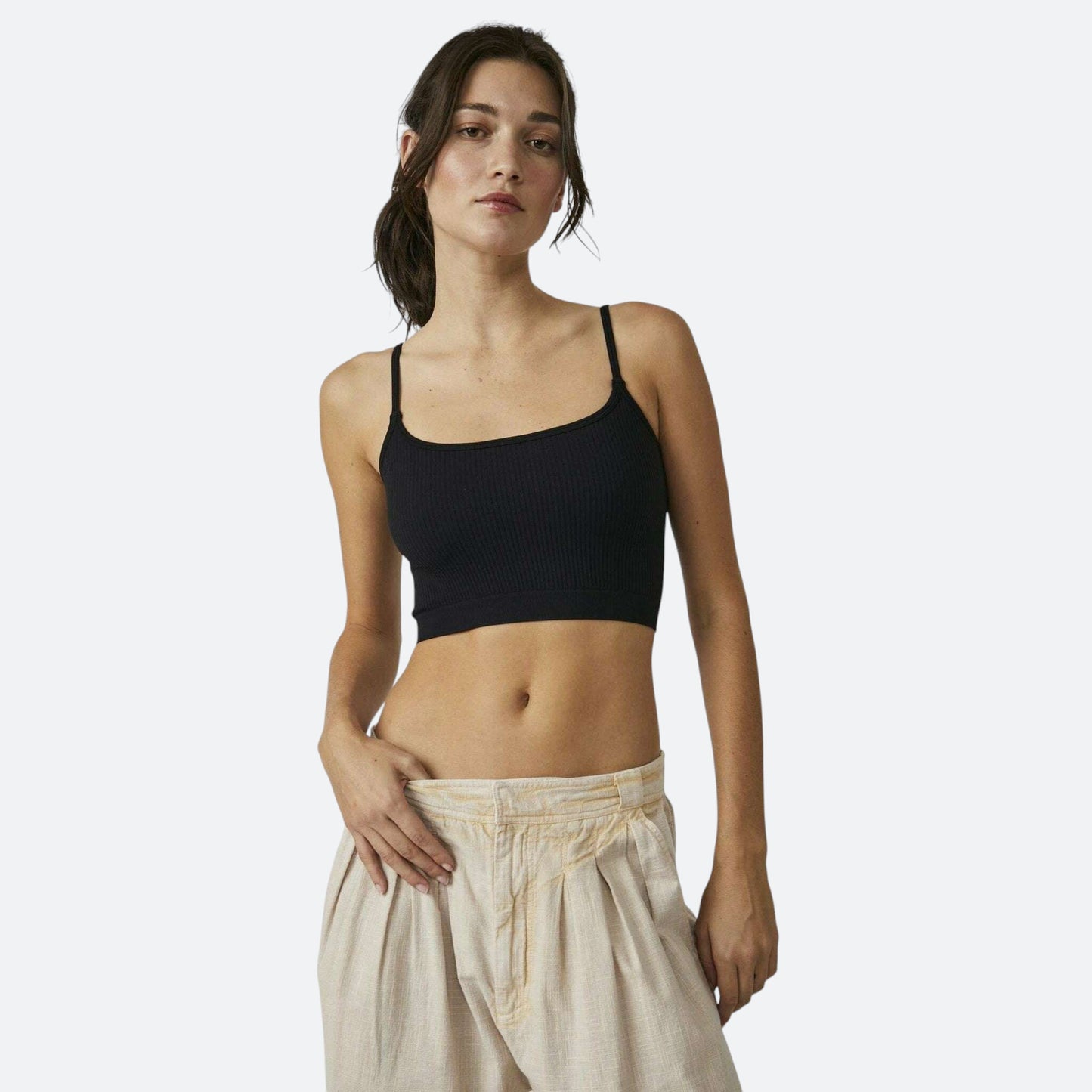 Plum Bottom Free People black ribbed brami worn by a model with light-colored trousers