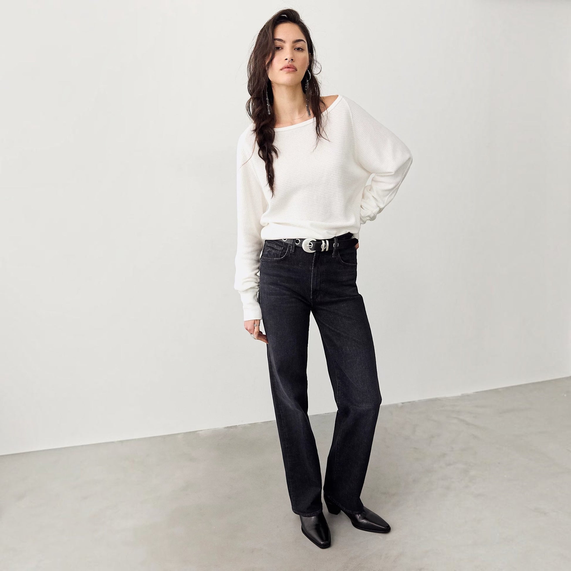 Plum Bottom model wearing a white Free People thermal long sleeve top with a boat neckline and black denim jeans.