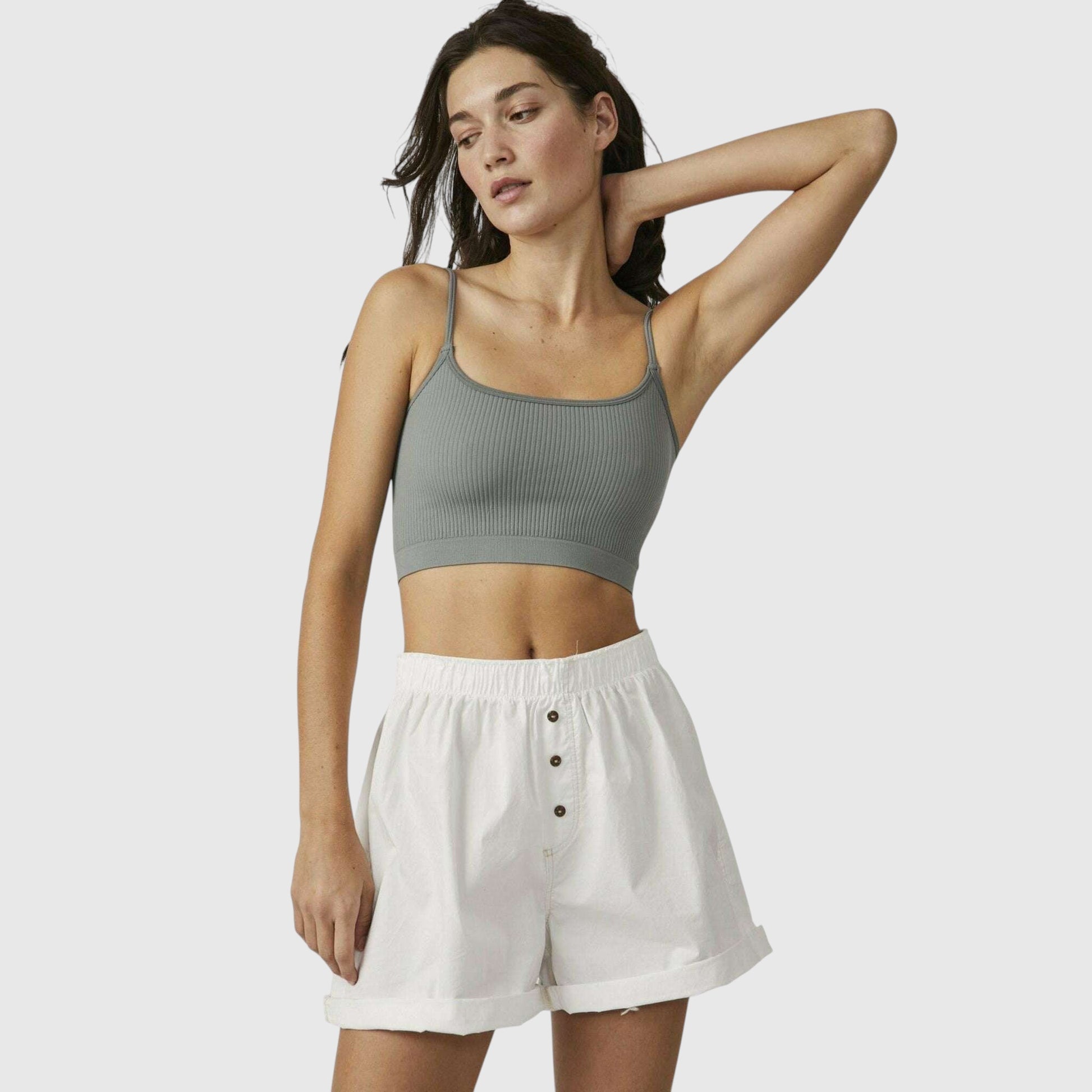 Plum Bottom model wearing a sage green ribbed brami and white button-front shorts against a neutral background