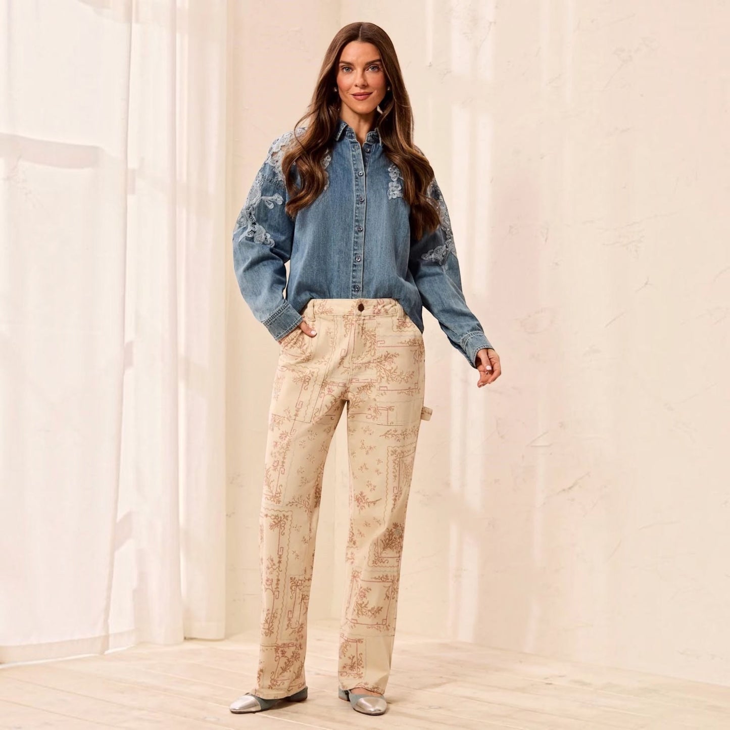 Plum Bottom model wears TRIBAL Audrey printed carpenter pants in Chantilly with a blue embroidered denim shirt.
