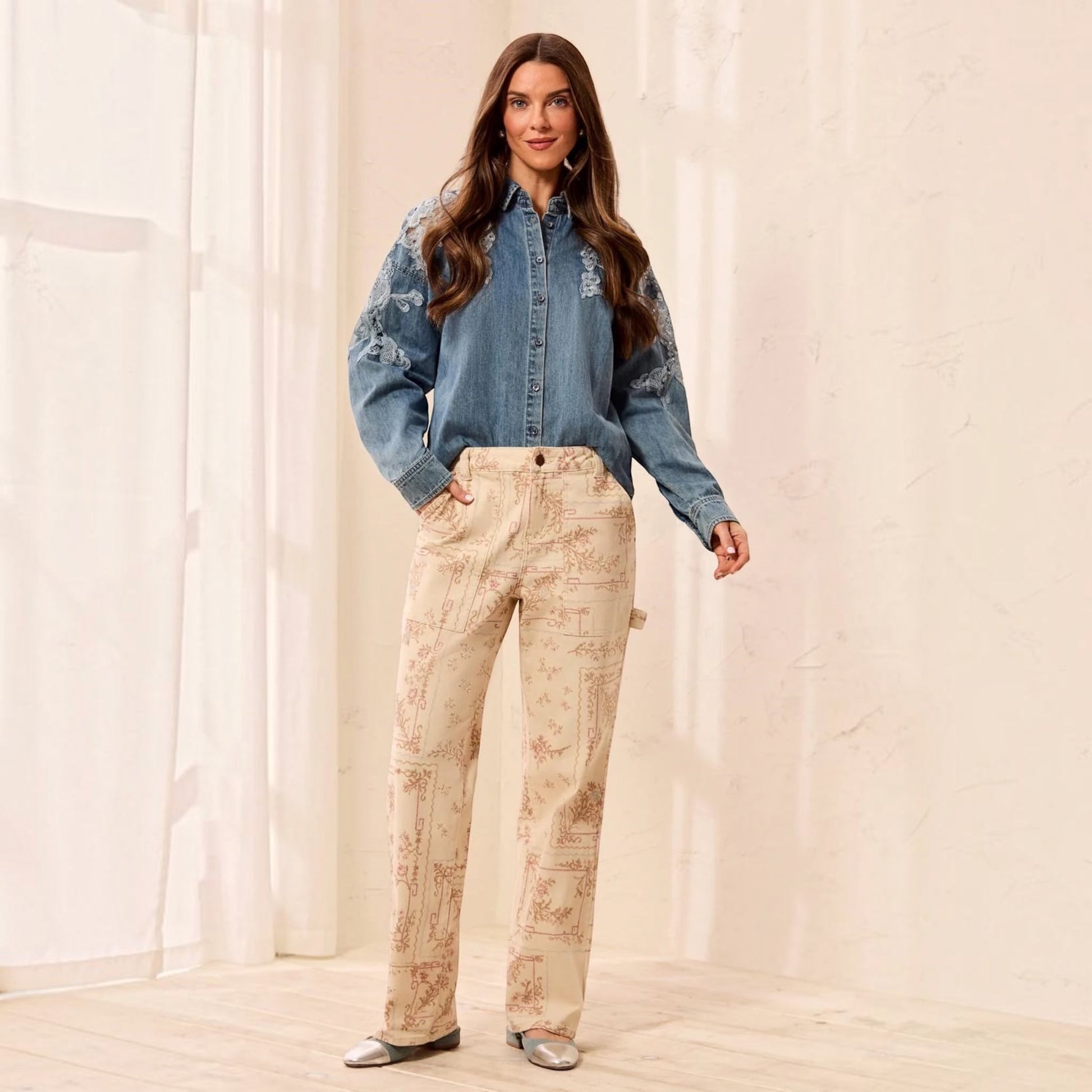 Plum Bottom model wears TRIBAL Audrey printed carpenter pants in Chantilly with a blue embroidered denim shirt.
