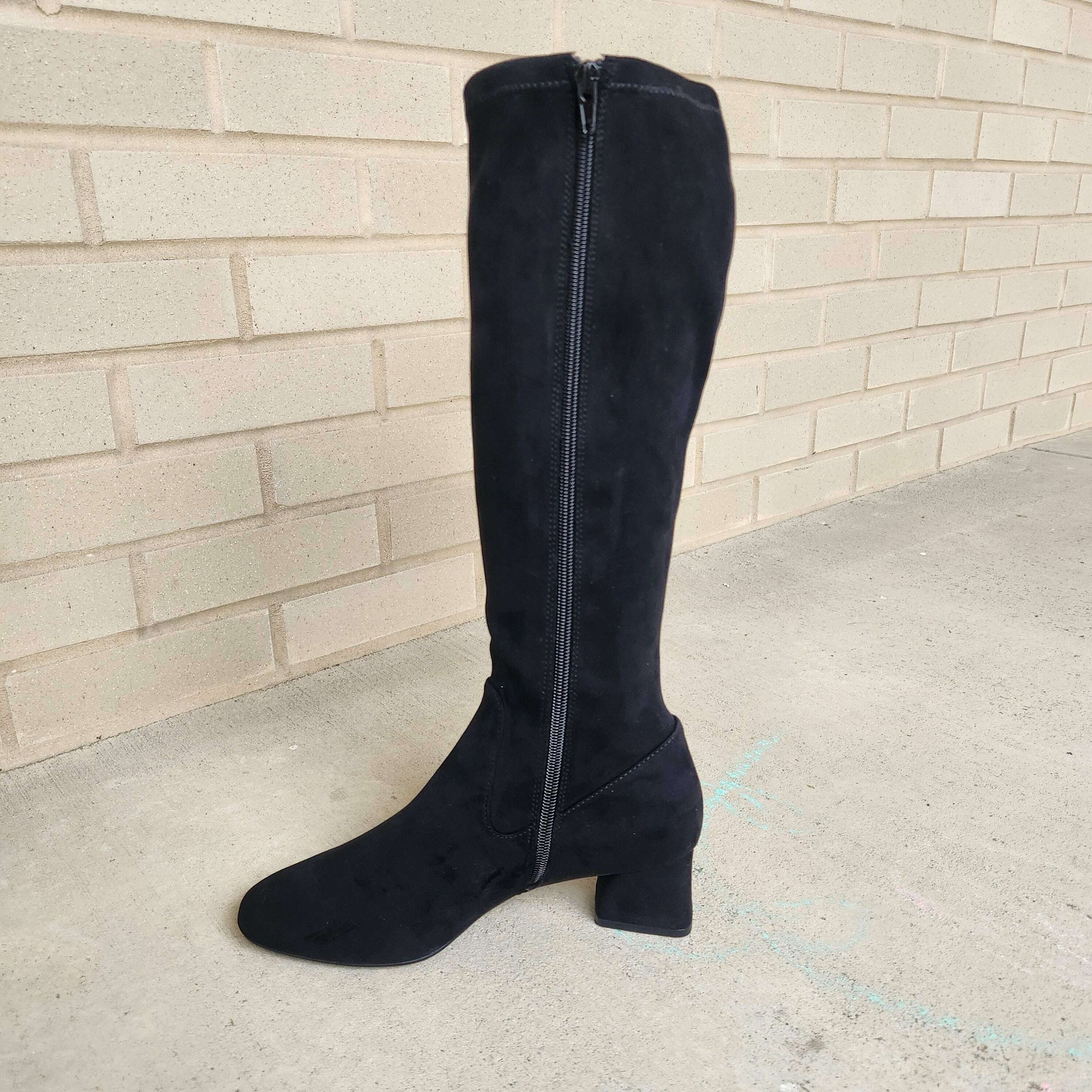 Plum Bottom VANELI Zovy black stretch suede tall boot with almond toe, side zip, and block heel on concrete surface.