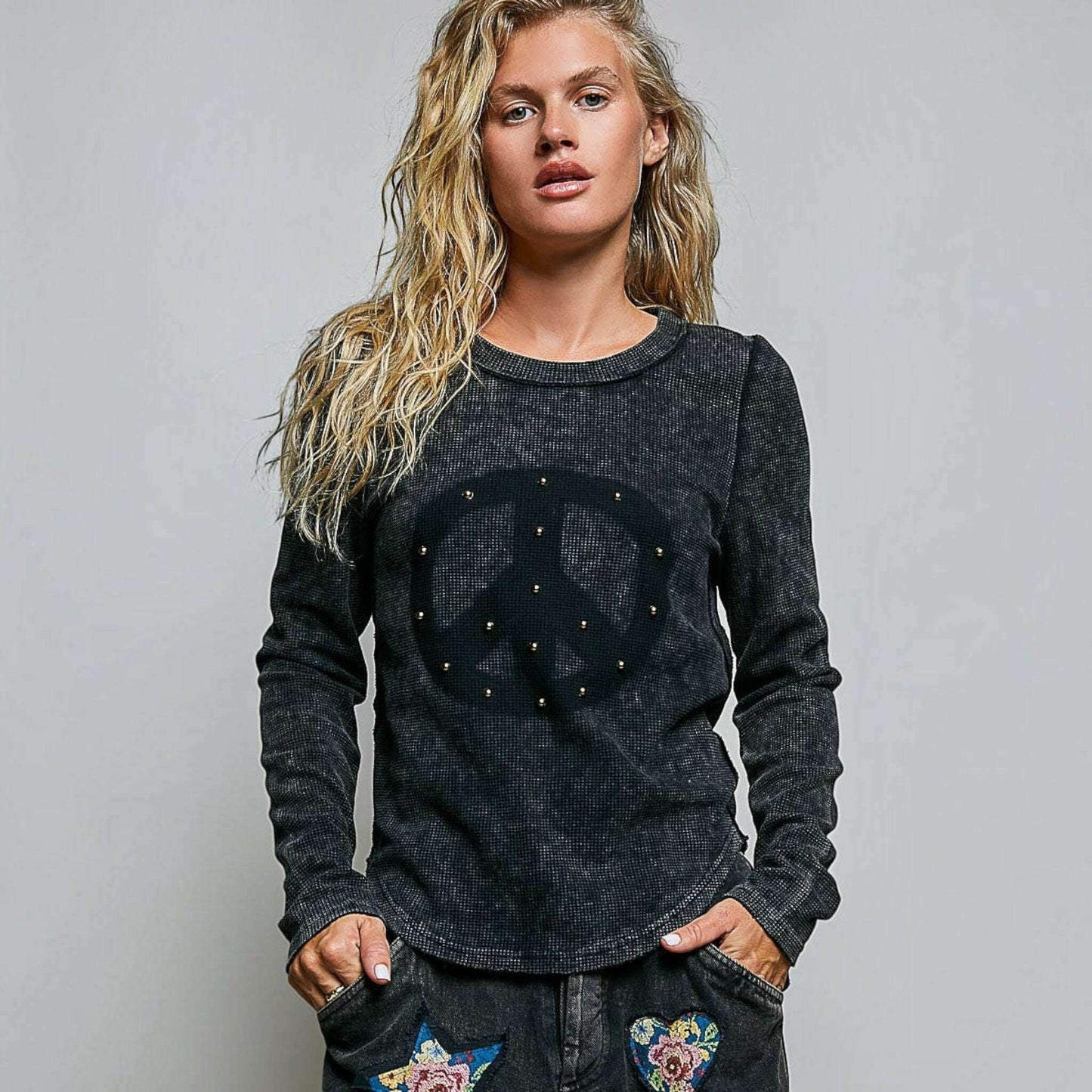 Plum Bottom thermal knit top in black with vintage wash, peace sign graphic, stud details, and outseam stitching.
