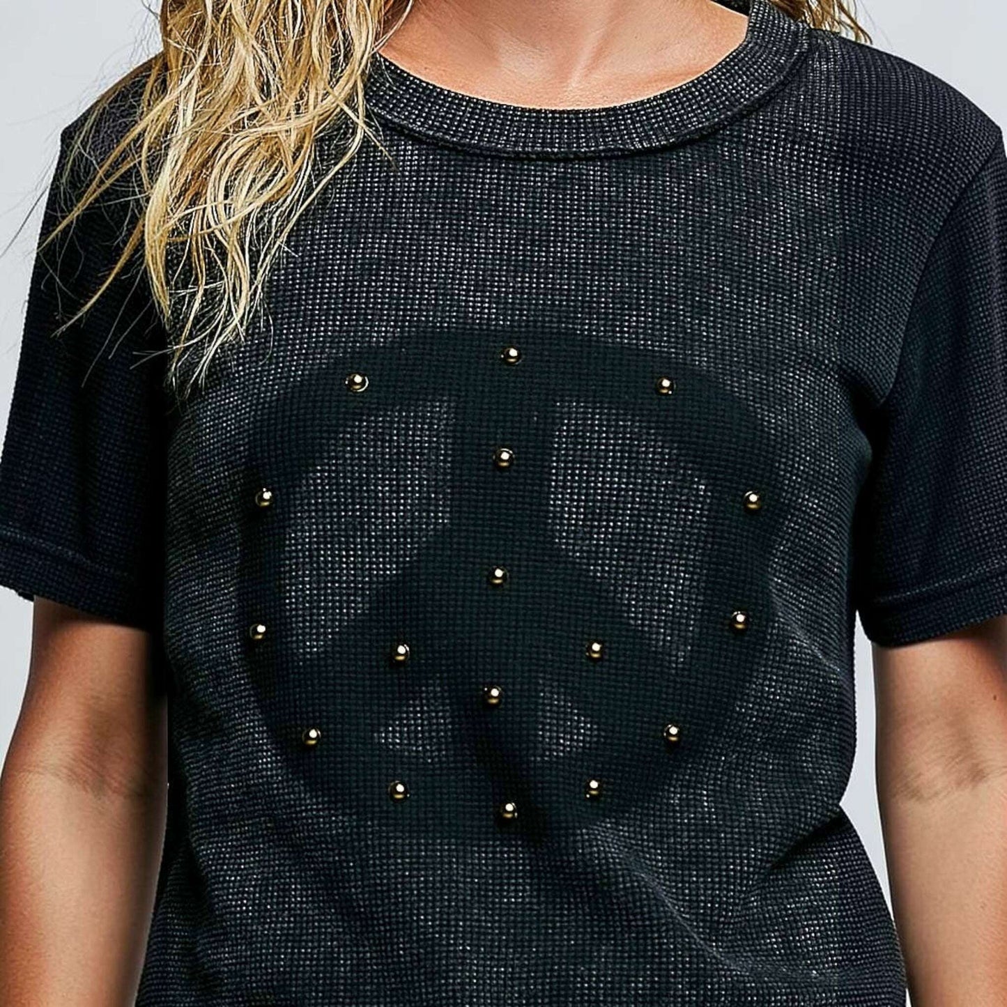 Plum Bottom black thermal knit top with a peace sign graphic, stud details, and reverse outseam stitching.