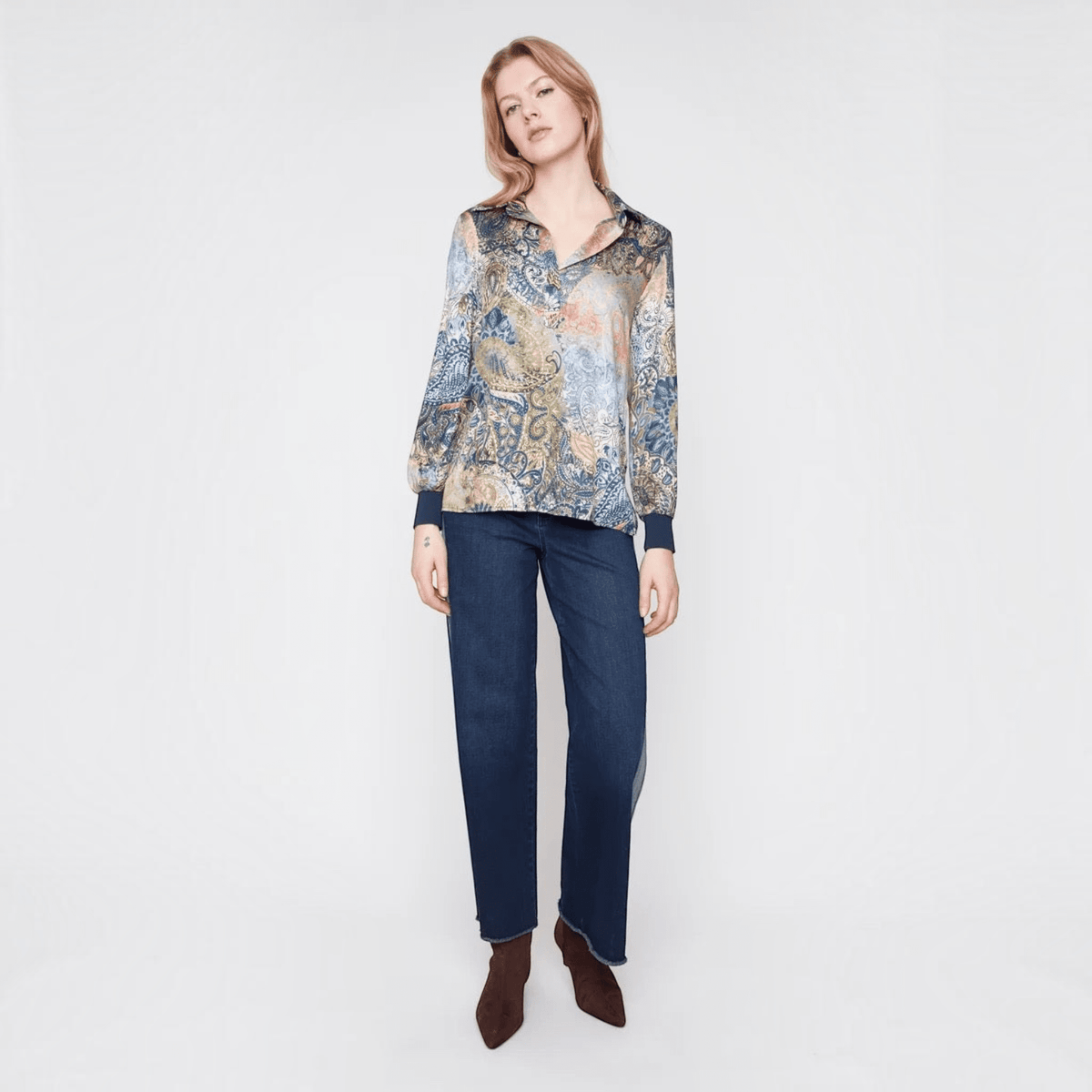 Model wearing a Plum Bottom RENUAR olive paisley print blouse with a collared neckline and navy blue cuffs.