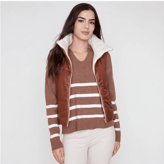 Model wearing a Plum Bottom RENUAR reversible cropped vest in brown and white over a striped sweater
