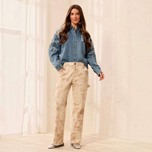 Plum Bottom model wears TRIBAL Audrey printed carpenter pants in Chantilly with a blue embroidered denim shirt.