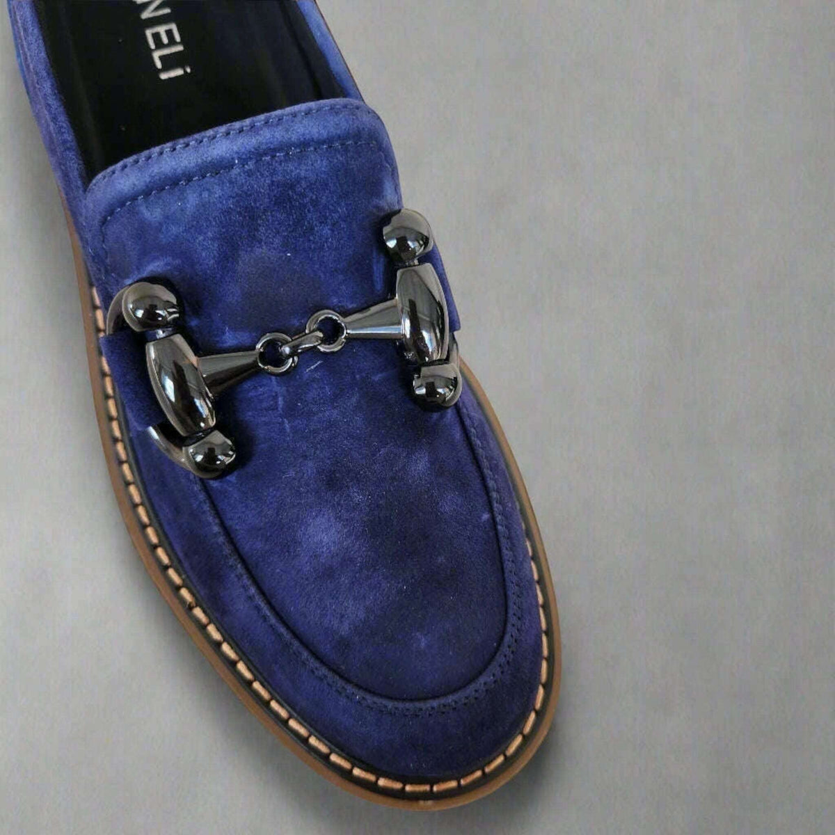 Plum Bottom VANELI Zimmy blue suede loafer with a shiny metal bit, lug sole, and contrasting tan welt stitching.
